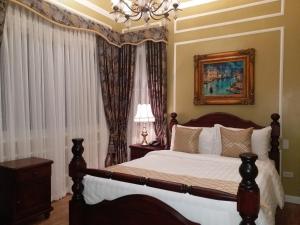 大雅台Lee Boutique Hotel Tagaytay的一间卧室配有一张床和一个吊灯