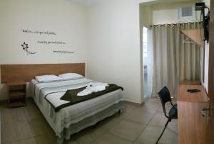 沃尔塔雷东达Pousada Casagrande - Roma的一间卧室配有带毛巾的床