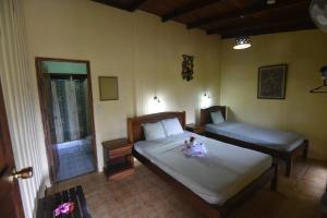 PitalLa Laguna del Lagarto Eco-Lodge的一间卧室配有两张床,上面有娃娃