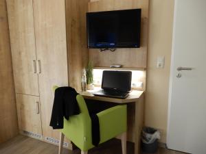 诺德代希艾姆哈丰酒店的客房设有带笔记本电脑的书桌和电视。