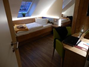 诺德代希艾姆哈丰酒店的小房间,配有一张床和一张桌子上的笔记本电脑