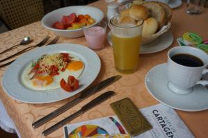 卡塔赫纳艾菲兹酒店的桌上放有一盘鸡蛋和水果,还有一杯咖啡