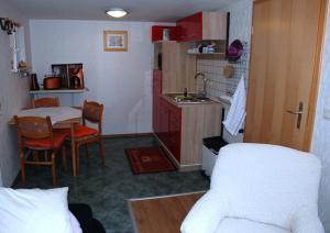 蒂索Ferienwohnung in Thiessow auf der的一间带桌子的小厨房和一间带沙发的厨房