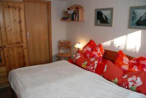 蒂索Ferienwohnung in Thiessow auf der的一间卧室配有红色和白色枕头的床