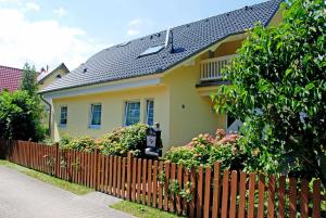 巴贝Ferienwohnung Schwalbennest的黄色的房屋,带有木栅栏和鲜花