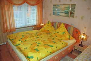 SehlenFerienwohnung Sehlen auf Ruegen的一间卧室配有一张带黄色棉被的大床