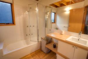 丁诺高原德罗维斯休闲度假屋的带淋浴、盥洗盆和浴缸的浴室