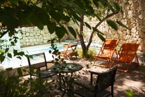 耶路撒冷阿莱格拉精品酒店的一组椅子和一张桌子,旁边是游泳池