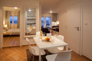 布尔诺Haas Apartments Stojanova with Parking的用餐室以及带白色桌椅的起居室。
