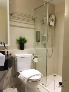 巴吞他尼Campagne Hotel and Residence - SHA Plus的一间带卫生间和玻璃淋浴间的浴室