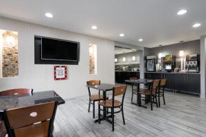 罗切斯特罗切斯特梅奥诊所区速8酒店的餐厅设有桌椅和平面电视。