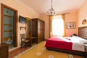 罗马安东尼旅馆的一间卧室设有红色的床和窗户。
