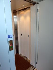 斯波莱托L'Ortolano Apartments的一座带玻璃门的办公楼内的电梯