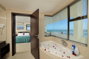 斯瓦科普蒙德斯瓦科普蒙德海滩酒店的带浴缸的浴室和卧室