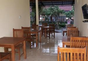 新加拉惹RedDoorz Plus @ Singaraja的一间空餐厅,配有木桌和椅子