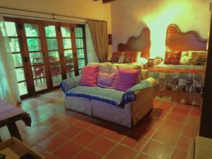 危地马拉安地瓜Cissus Hotel Boutique的客厅配有椅子和床