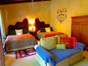危地马拉安地瓜Cissus Hotel Boutique的一间卧室配有两张床和一张沙发。