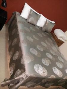 布里斯班汉普顿酒店式公寓的一张带白色枕头的灰色床罩床
