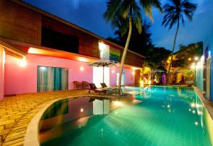 尼甘布迪克曼度假村“精品酒店”的夜间在房子前面的游泳池