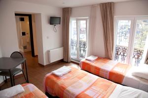 布鲁塞尔巴瑞酒店的酒店客房设有三张床和阳台