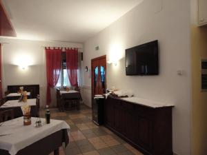 蒙泰基奥马焦雷圣马可酒店的一间用餐室,配有一张桌子和一台墙上的电视