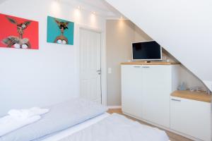 万根沃格Living-art的一间白色卧室,配有床和电视