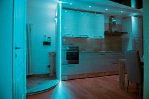 阿科阿科豪华公寓式酒店的厨房配有白色橱柜和蓝色灯