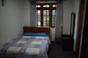 努沃勒埃利耶Cecilia Cottage的一间卧室设有一张床和一个窗口