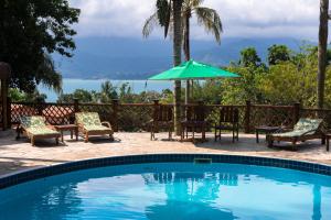 伊利亚贝拉达普赖尼亚波萨达酒店的一个带椅子和遮阳伞的游泳池