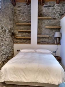 莫尔吉斯Vilamaroto的一间卧室配有一张石墙床