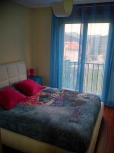 GibajaApartamento La Gloria的一间卧室设有一张床和一个阳台的窗户。