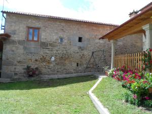 欧特斯Casa Barqueiro的享有带鲜花的石头房子的外部景色