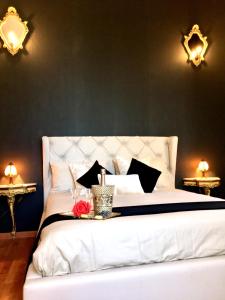罗马斗兽场甜蜜公寓的卧室配有一张带两个灯的大白色床