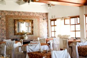 阿肖海马尔阿霍旅馆的配有桌子、白色椅子和镜子的房间