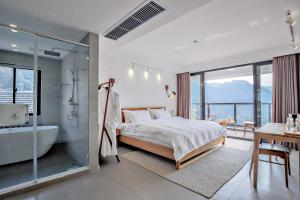 杭州杭州三宿酒店的一间带浴缸和床的卧室以及一间浴室。