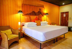 尼甘布迪克曼度假村“精品酒店”的一间卧室配有一张大床和一把椅子