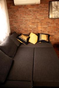 巴利亚多利德El Palomar的砖墙边的沙发,上面有枕头