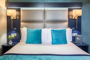 巴黎Prince Albert Montmartre的一间卧室配有一张带蓝色枕头的大床