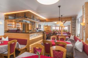 拉姆绍达赫斯坦Gasthof Edelbrunn的一间带桌椅的餐厅和一间酒吧