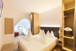 格洛伦萨贝尔维纳精品酒店的卧室配有白色的床铺和白色的枕头