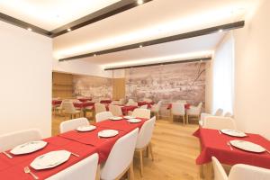 格洛伦萨贝尔维纳精品酒店的用餐室配有红色桌子和白色椅子