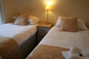 布莱斯The Angel Inn (Blyth)的一间卧室配有两张床和床头灯。