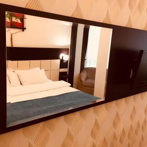加济安泰普布尤克威力克酒店的镜子反射着一间卧室,卧室配有一张床和椅子