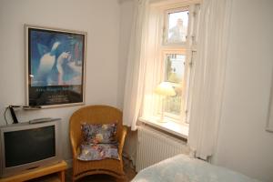 哥本哈根威尔斯住宿加早餐旅馆的一间卧室配有电视、椅子和窗户。