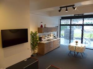 奥尔西讷volcaloft的厨房配有桌子,墙上配有电视