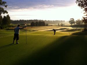 LjungsbroVreta Kloster Golfklubb的两人在高尔夫球场打高尔夫