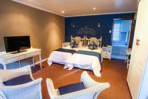 斯托姆勒菲齐齐卡马村酒店的一间卧室配有两张床、一台电视和椅子