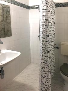 金沙艾尔菲别墅酒店的浴室配有淋浴帘和盥洗盆。