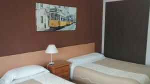 圣地亚哥－德孔波斯特拉圣丽塔旅馆的一间卧室配有两张床,一张火车照片