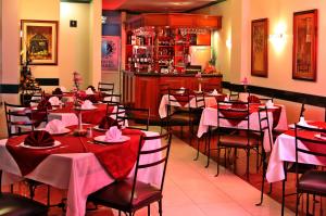 昆卡亚努凯伊酒店的餐厅设有红色和白色的桌椅